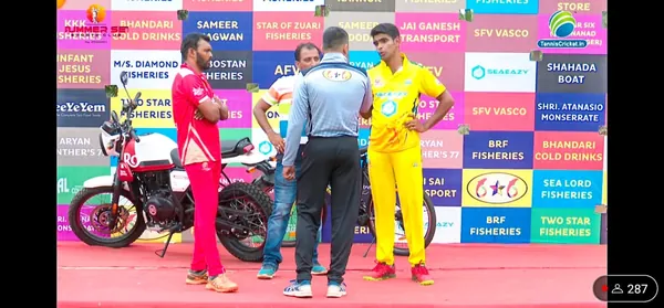 Captains and the umpire at the toss in front of a sponsor wall